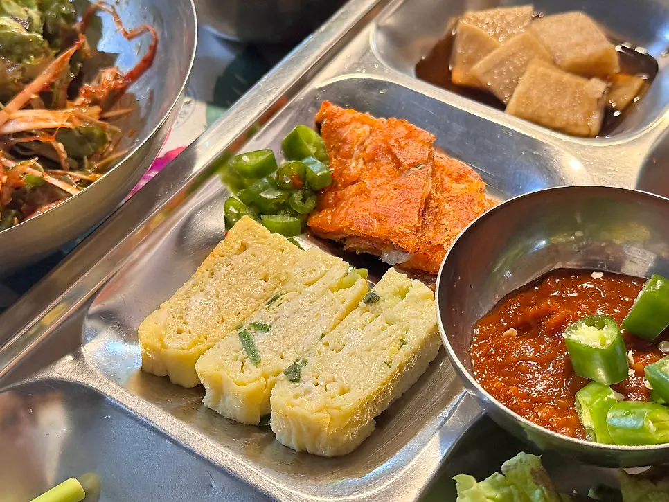 Rolled egg and kimchi pancake on the tray of banchan