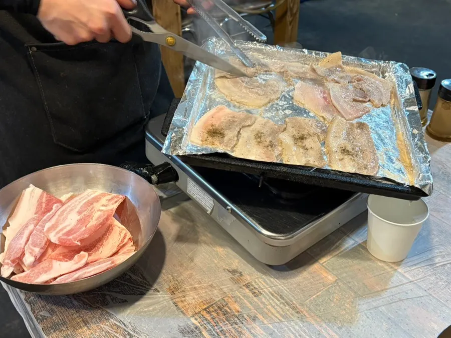 Frozen pork belly being grilled on the barbecue