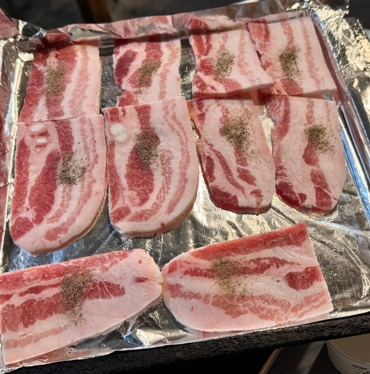 Frozen pork belly laid on the foil-lined grill pan