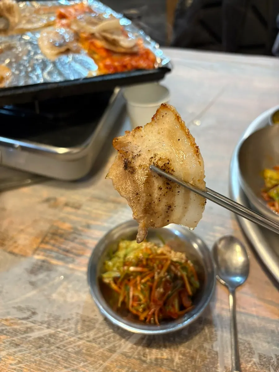 Frozen samgyeopsal and kimchi cooking on medium heat