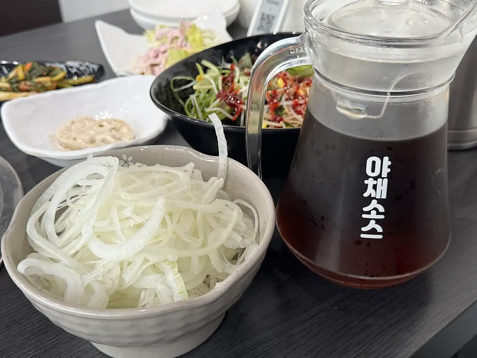 A spread of Sodam Galbi side dishes including honey sweet pumpkin and mustard leaf kimchi
