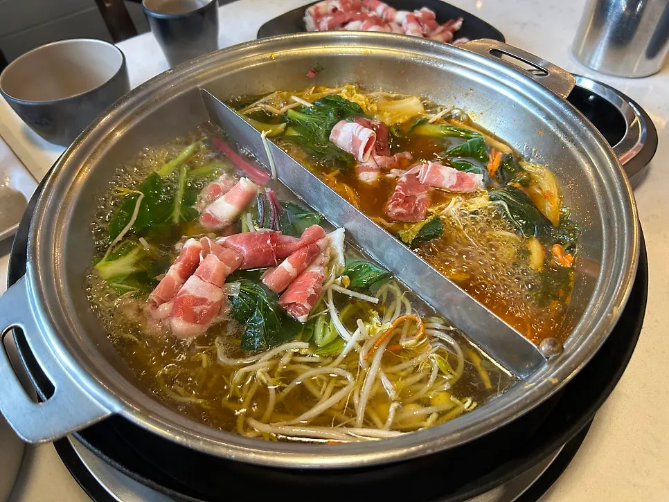 A pot of shabu shabu simmering with meat and vegetables