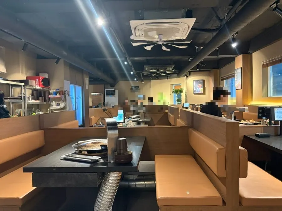 Wide tables with hood above the cauldron-lid grill