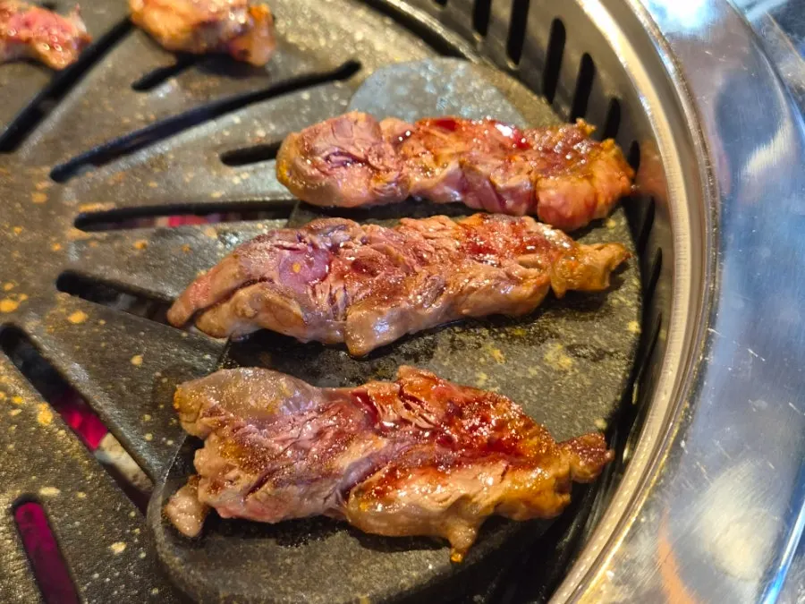 A tableside view of the meat being grilled