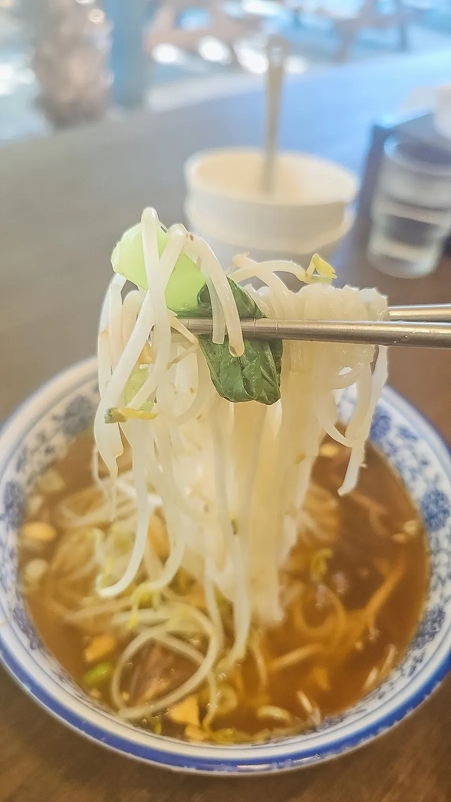 Large chunks of braised beef shank on top of the rice noodle soup