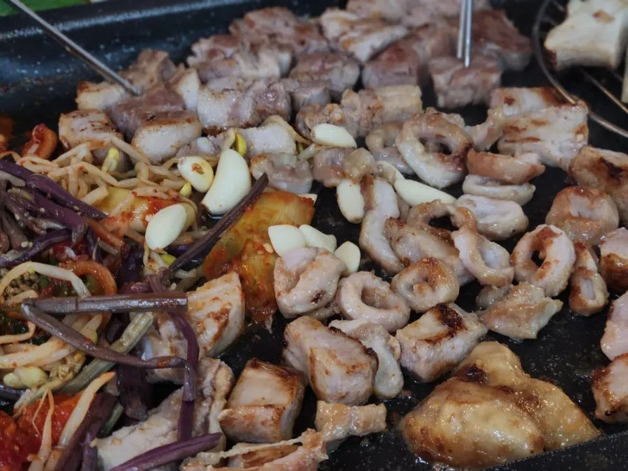 기울어진 돌판에 구워지는 삼겹살과 막창