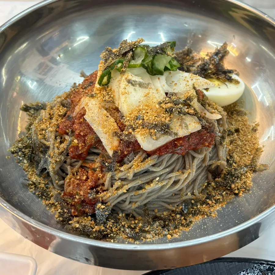 Buckwheat makguksu topped with pickled radish and seasoned sauce