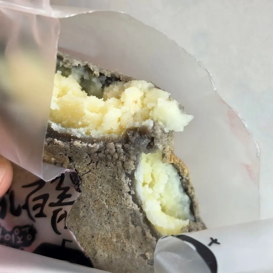 Potato bread broken open to show its yellow potato filling