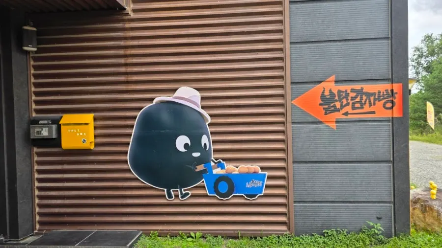 Exterior of Sokcho Bultan Gamja Bread Main Store building with potato illustrations