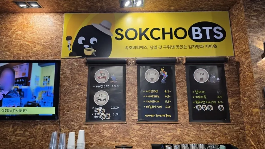Store entrance with a charred-looking black potato illustration