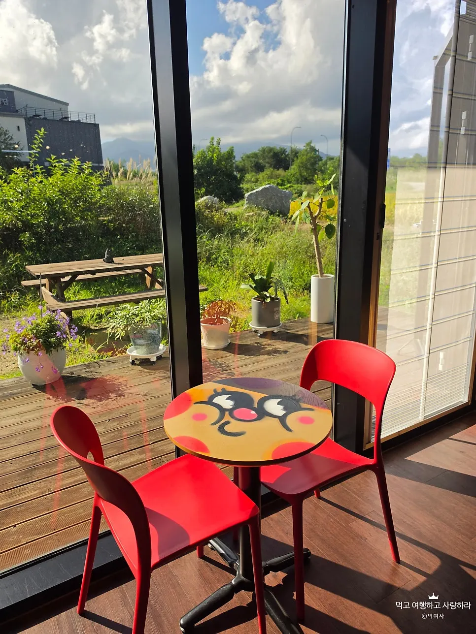 Red chairs and character-illustrated table by the window