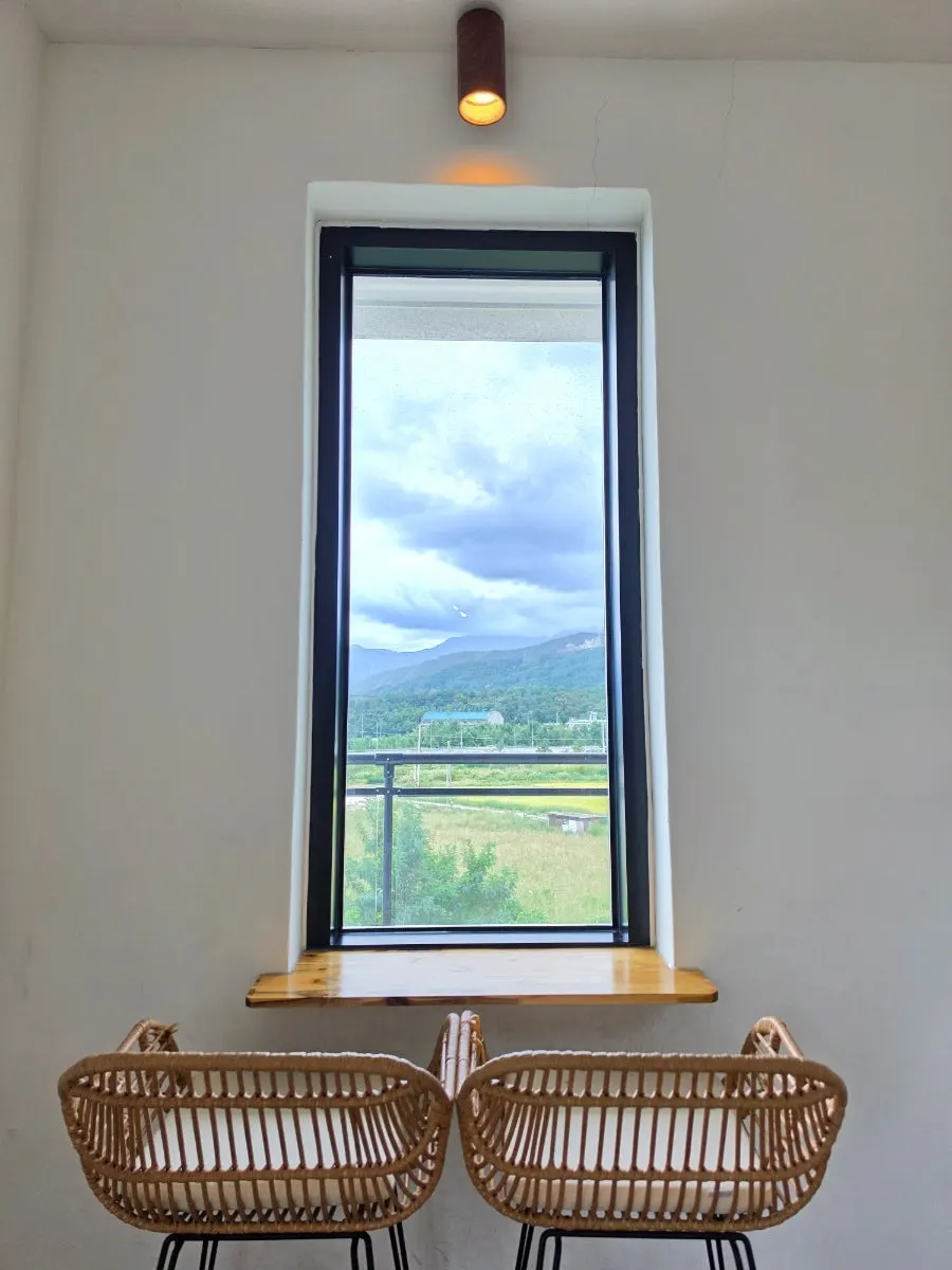 Sunlit floor-to-ceiling window interior at Cafe Neorae