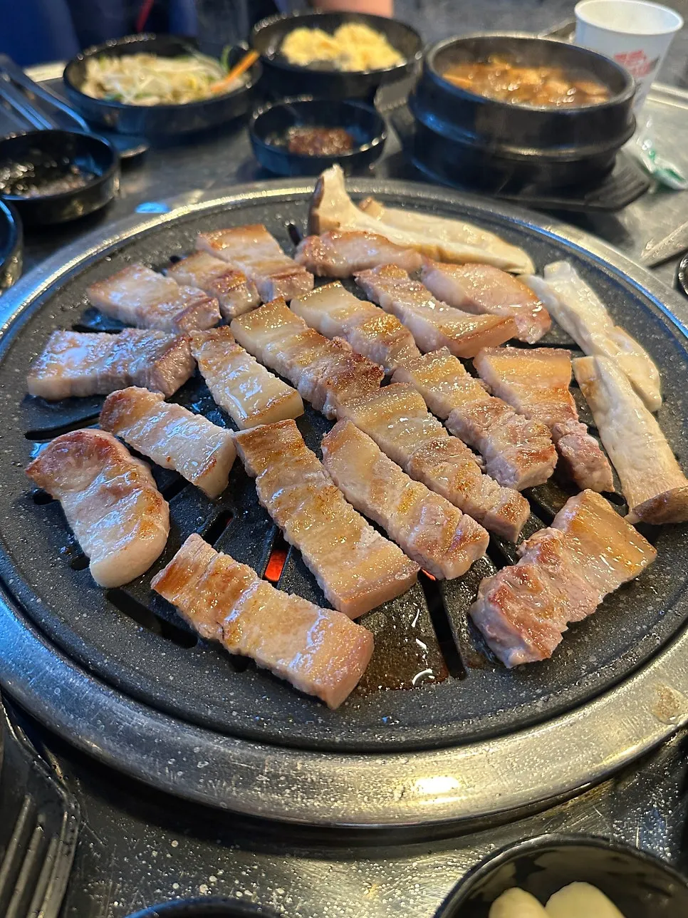 Pork belly grilling over charcoal