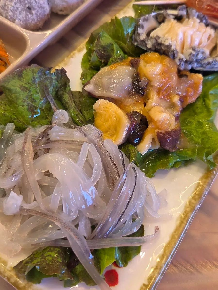 Squid sashimi and other seafood banchan