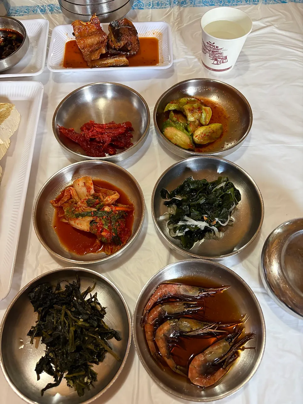 Basic side dishes including kimchi, seasoned cucumber, namul, and shrimp in soy sauce