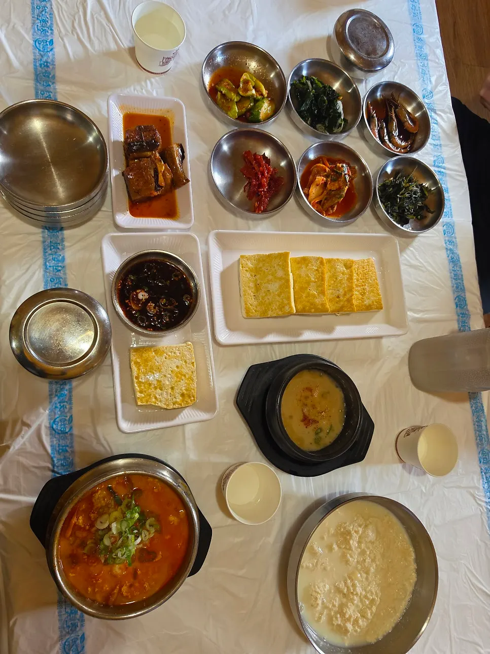 Full table spread with sundubu, pan-fried tofu, and side dishes