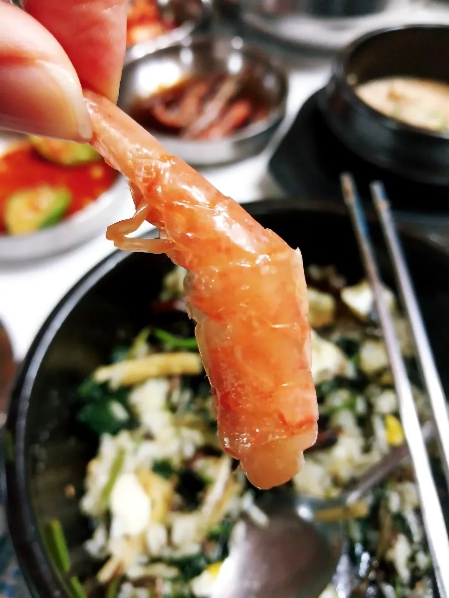 A meal scene with cucumber muchim on the side