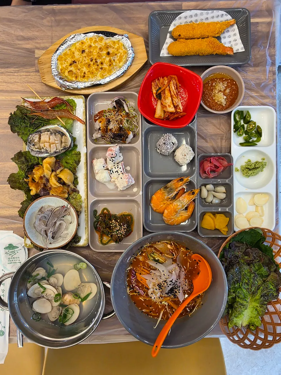 Table full of raw fish restaurant banchan side dishes