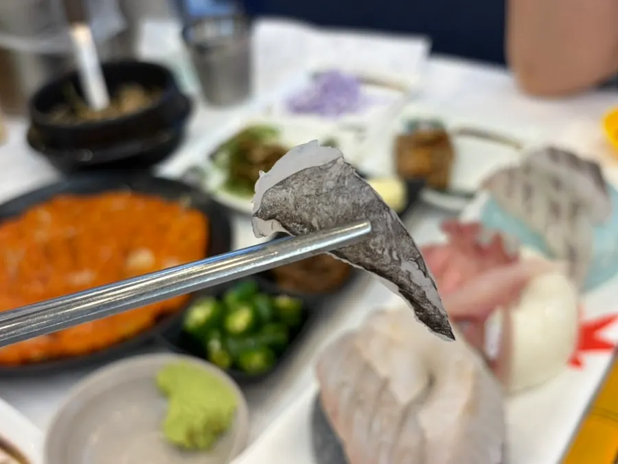 Picking up a piece of fresh sashimi