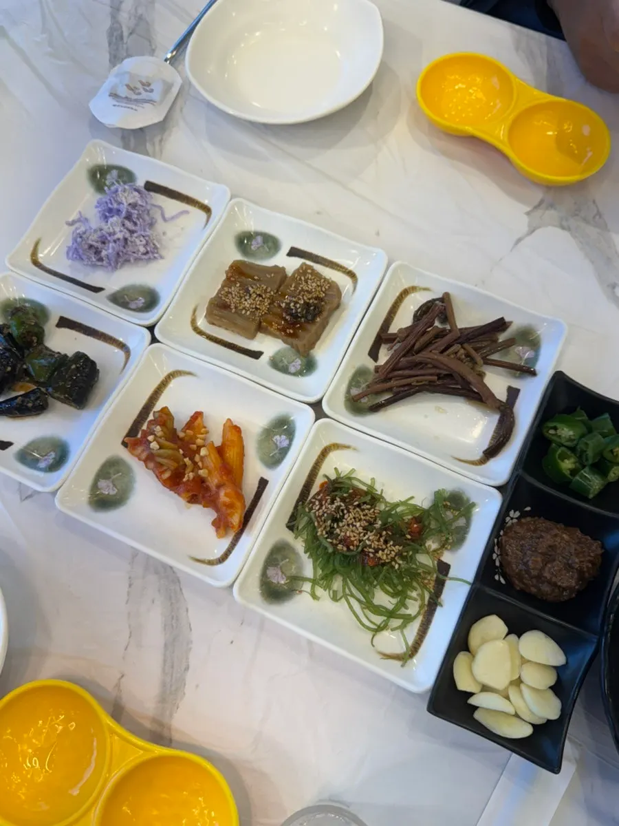 Acorn jelly and seasoned vegetable side dishes served before the sashimi