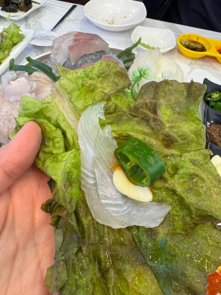 A lettuce wrap with sashimi and garlic