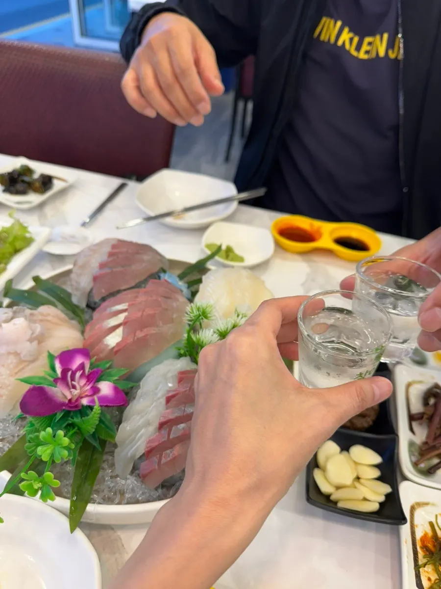 Sashimi and a glass of soju at the ocean-view window seat