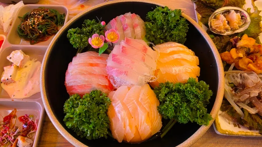 Live fish sashimi plate garnished with a flower