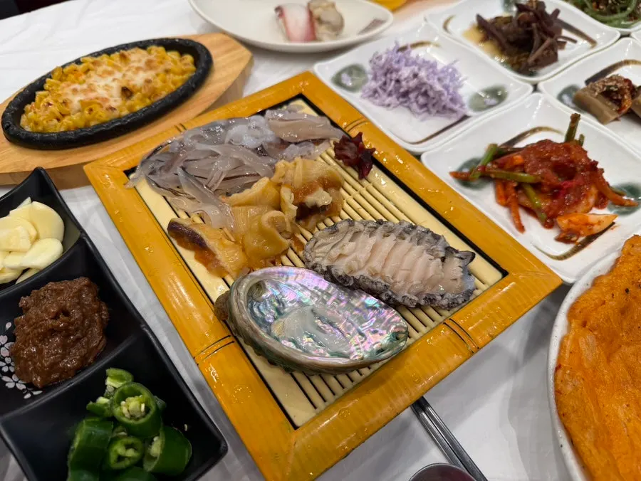 Sea squirt, abalone sashimi, and squid sashimi served as banchan