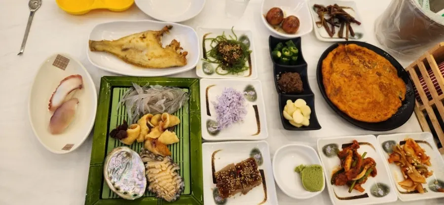 Seafood trio set of grilled flounder, abalone, sea squirt, and live squid sashimi