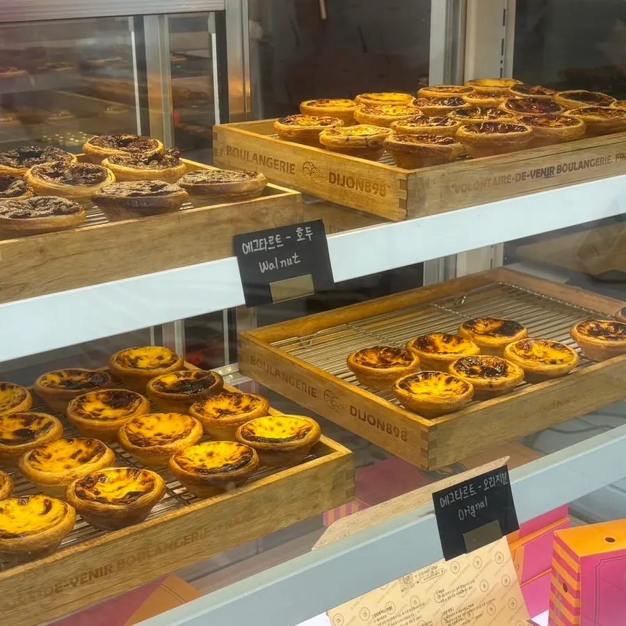 Egg tarts and baked pastries displayed in the case
