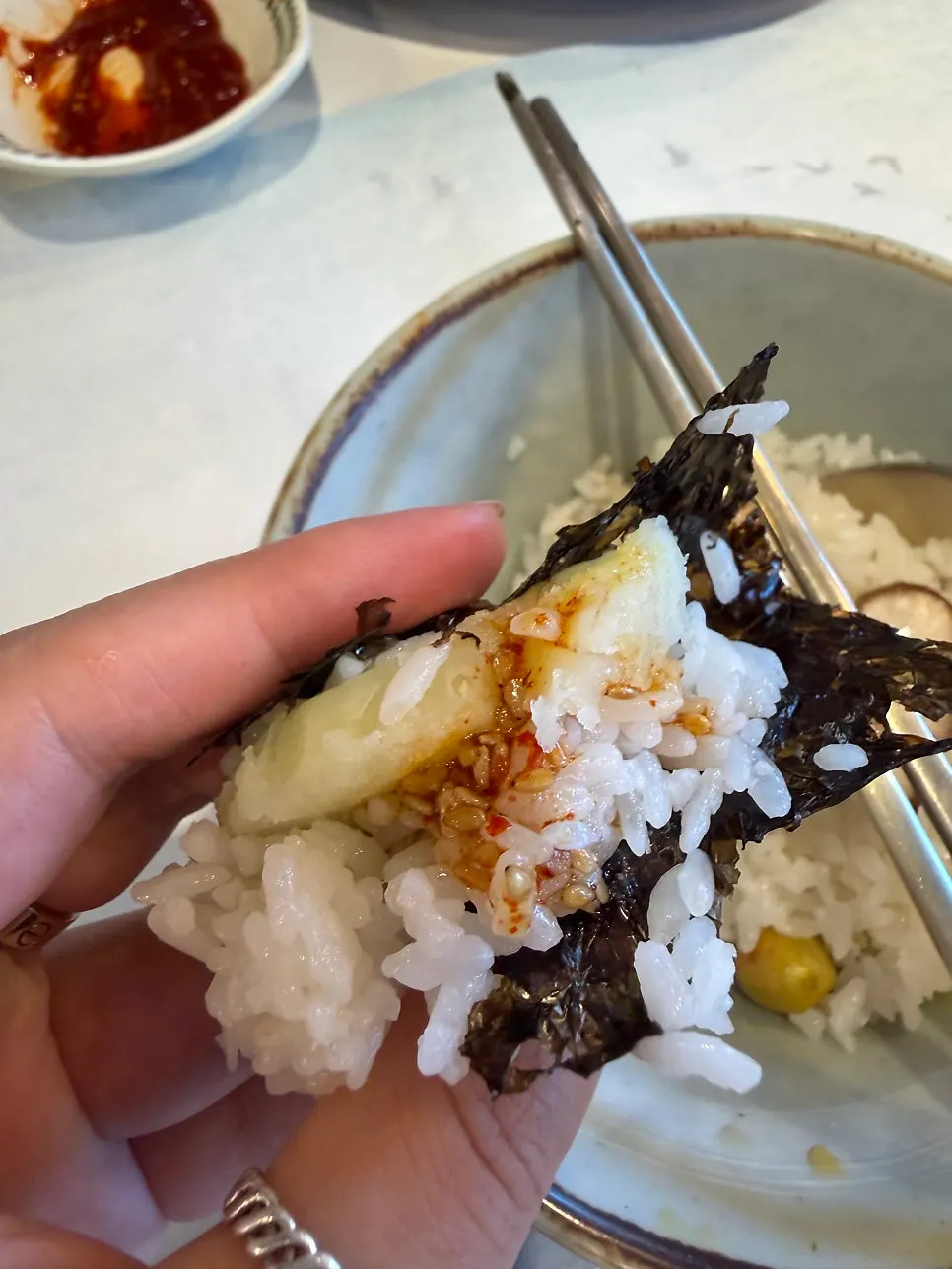 A spoonful of potato hotpot rice topped with seafood