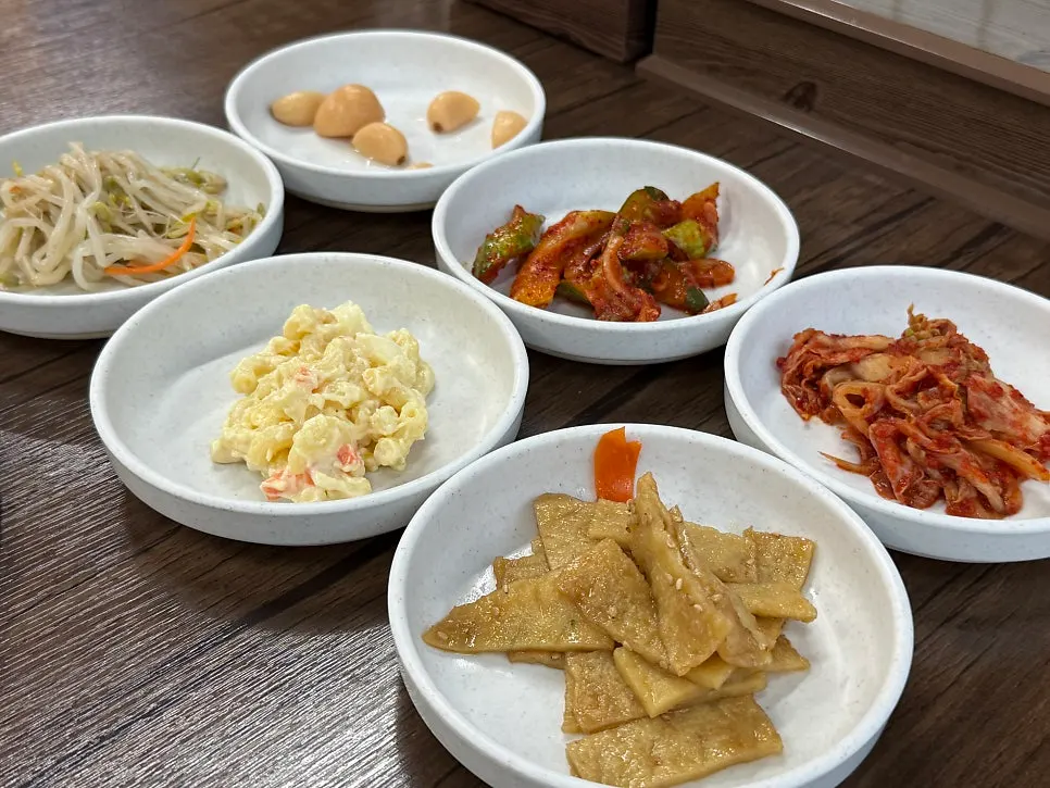 Basic side dishes at Gwandongjip including bean sprouts and stir-fried fish cake