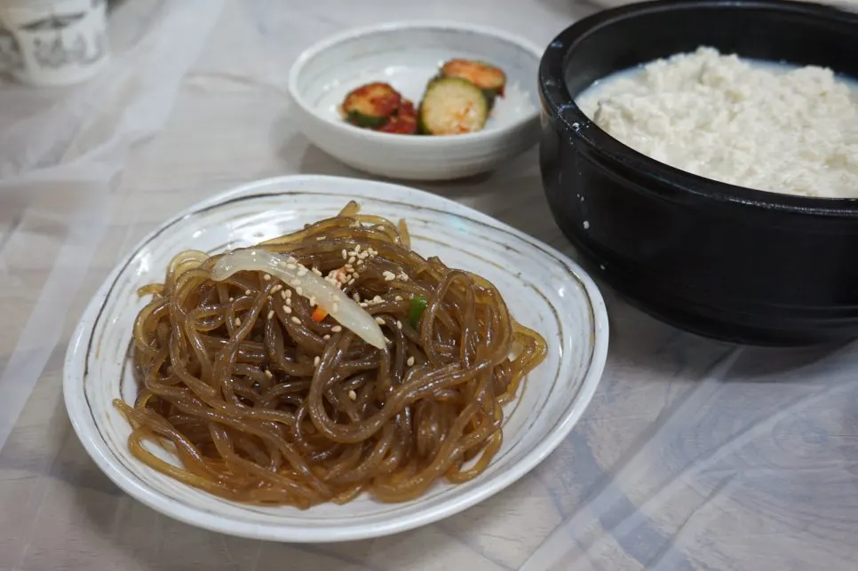 Banchan spread including squid jeotgal, stir-fried anchovies, and cucumber kimchi