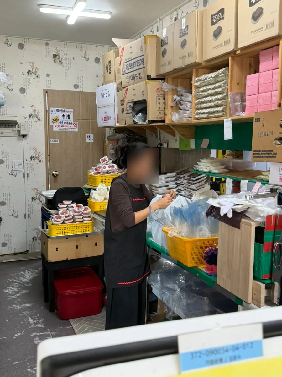 주방 뒤에 쌓여 있는 회 포장용기