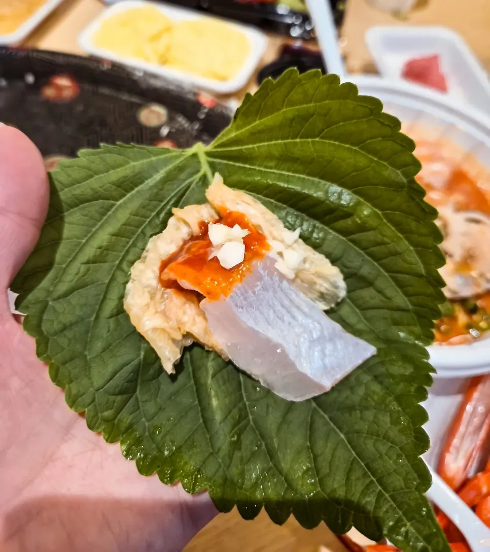 Side dishes including lettuce wraps, sushi rice, and aged kimchi laid out