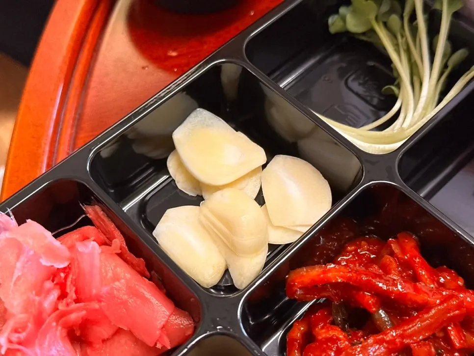 Dipping the mixed sashimi in soy sauce and vinegar-chili sauce