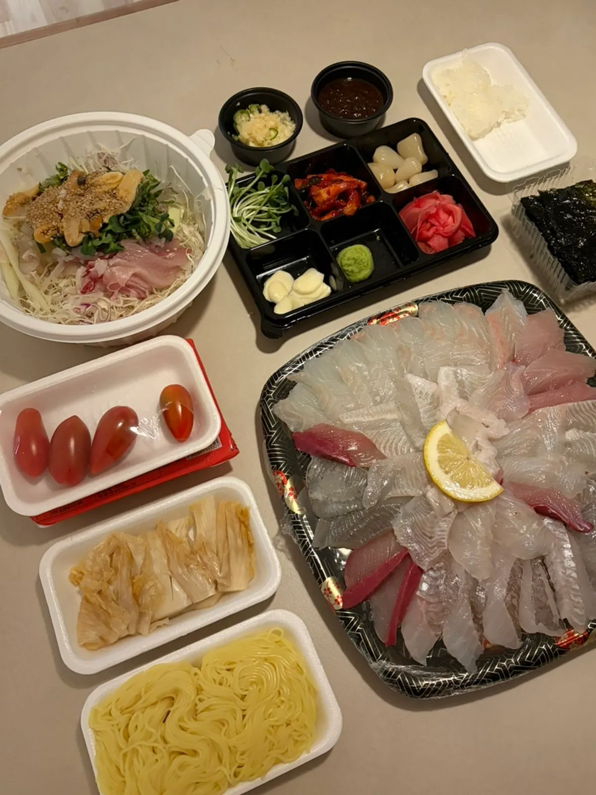 Small mixed sashimi and mulhoe takeout spread in a hotel room