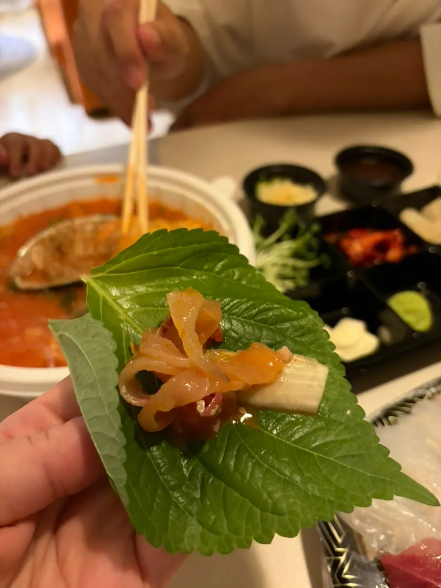 Baby eating cherry tomatoes next to the sashimi spread