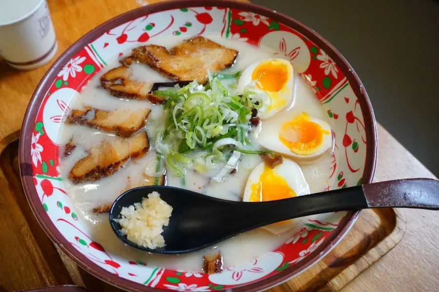 Char siu from Ichiba Ramen held with chopsticks