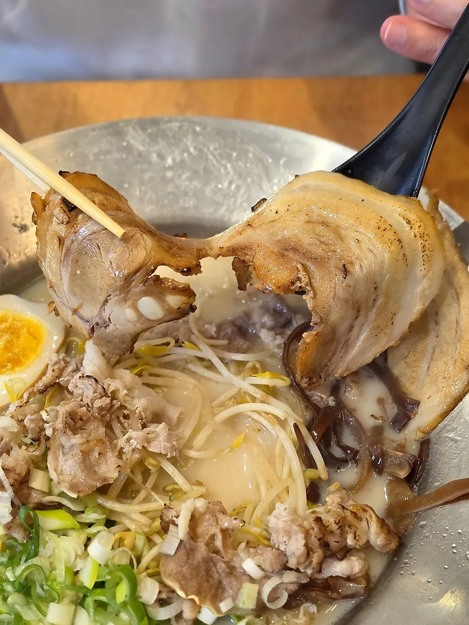 A spoonful of the rich, dark tonkotsu broth