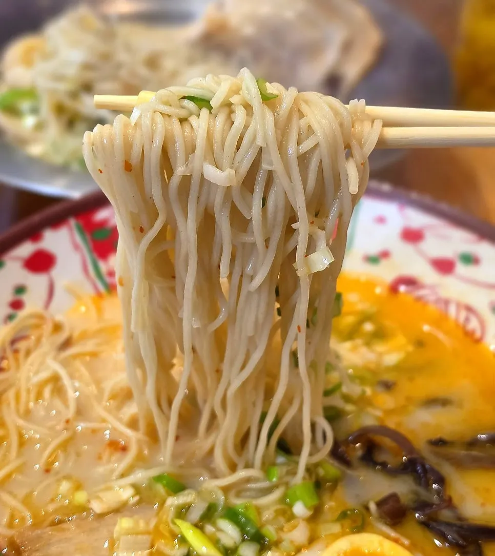 A spoonful of karai ramen broth lifted from the bowl