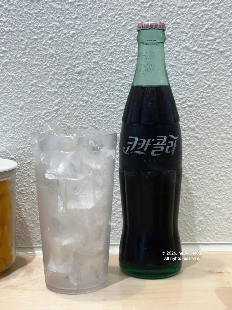 Nostalgic bottled cola served with a cup of ice