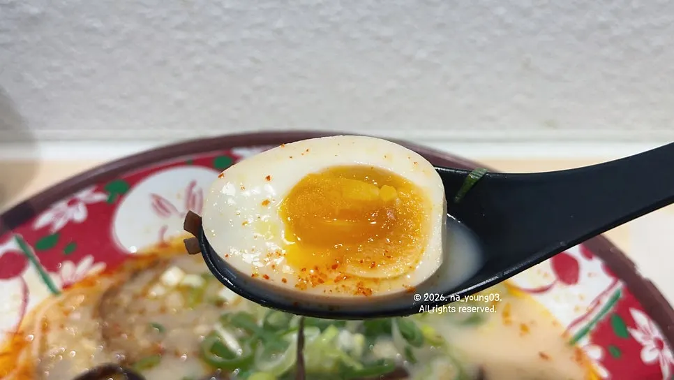Chashu and soft-boiled egg on top of karai ramen