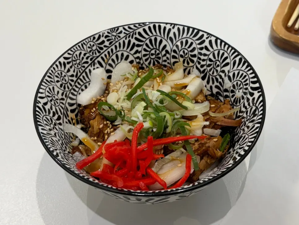 Lifting up ramen noodles and chashu with chopsticks