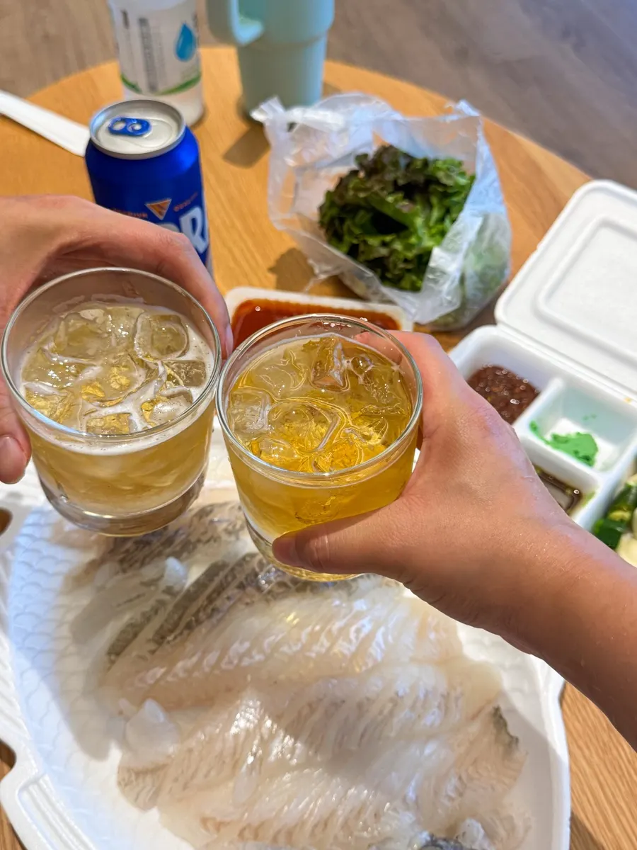 A drink poured alongside the sashimi platter