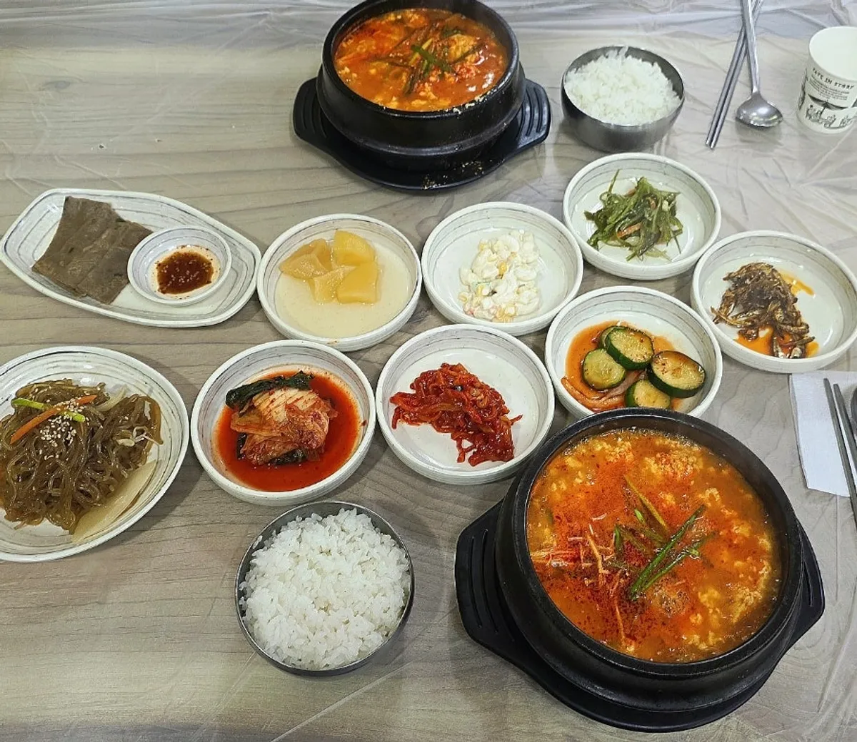 Table setting with jjamppong seafood sundubu for two and side dishes