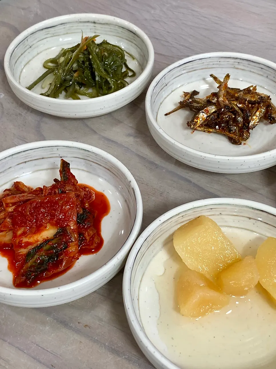 Side dish spread including japchae and buckwheat pancake