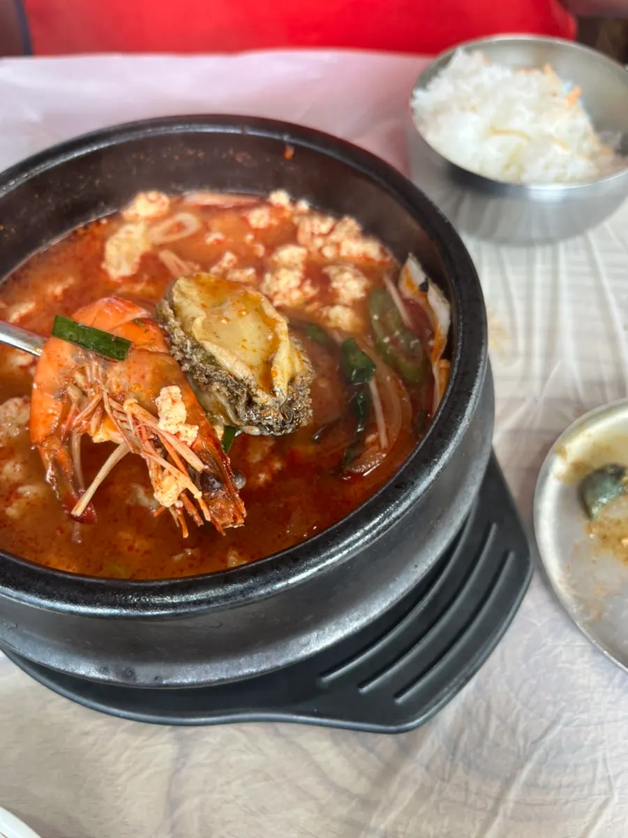 Table spread with spicy seafood sundubu and wild greens bibimbap