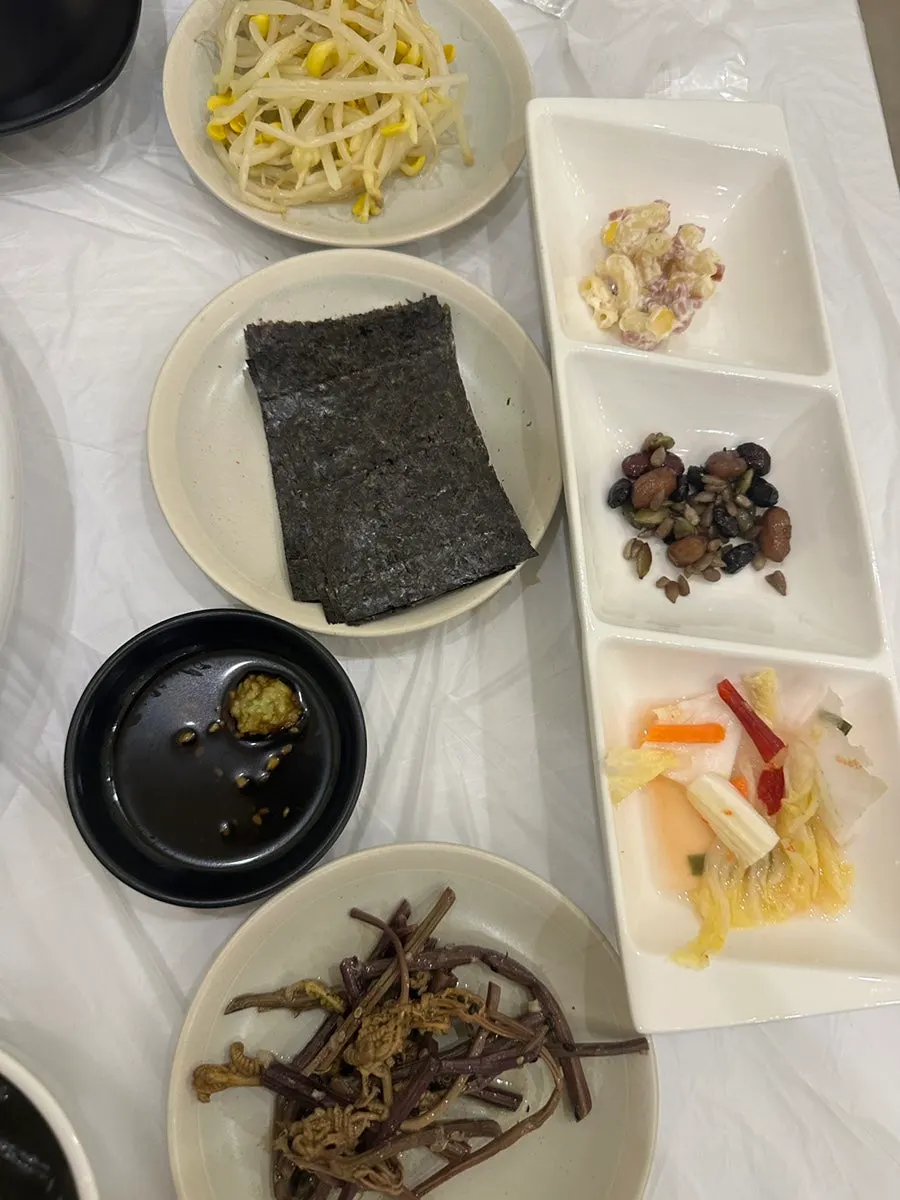 Side dishes of soy sauce and wasabi, seaweed and bean sprouts