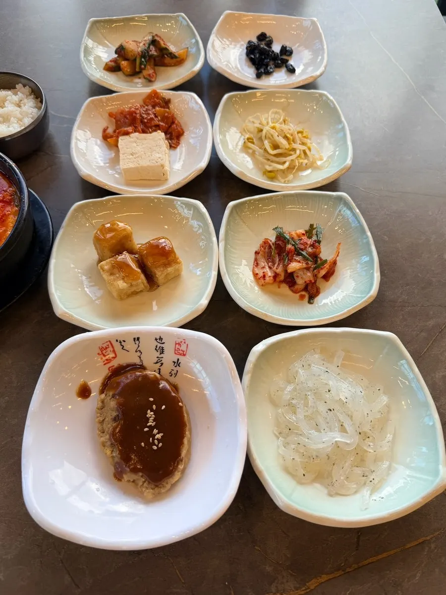 반찬 8가지와 공기밥이 놓인 테이블